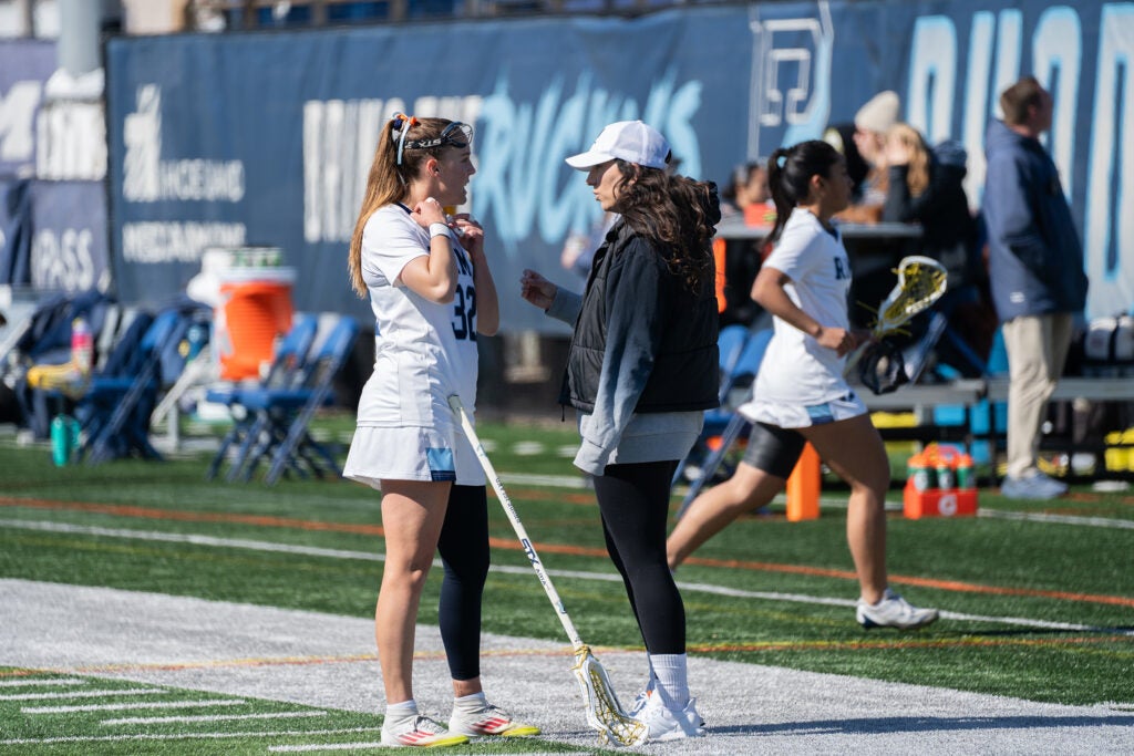 URI women's lacrosse players celebrating a goal during their inaugural NCAA season