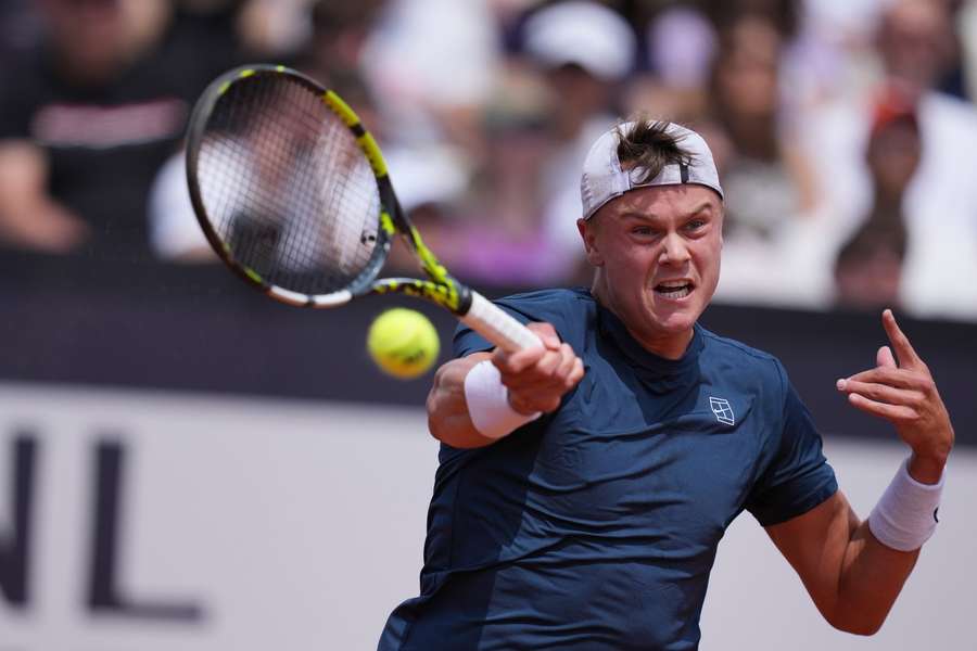Holger Rune on court in Rome, focused during a dramatic point.