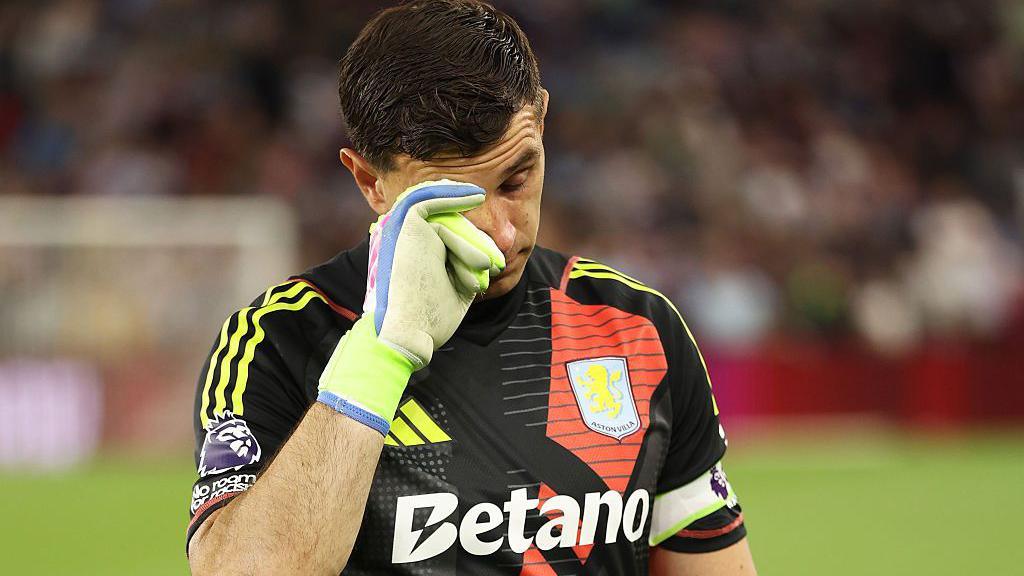 Aston Villa goalkeeper Emi Martinez waves farewell to fans